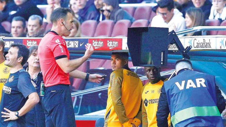 El árbitro Guillermo Cuadra Fernández consulta el VAR durante el partido entre el Fútbol Club Barcelona y el Getafe Club de Fútbol. Foto: Enric Fontcuberta. 