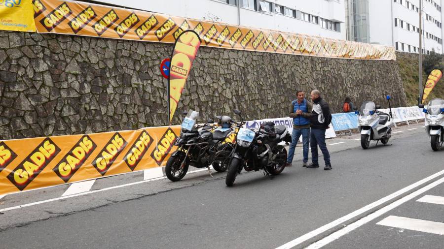 Algunas de las motos que prestan apoyo a la Carreira Pedestre de Santiago esperan a que llegue el momento de la salida ante las pancartas de Gadis