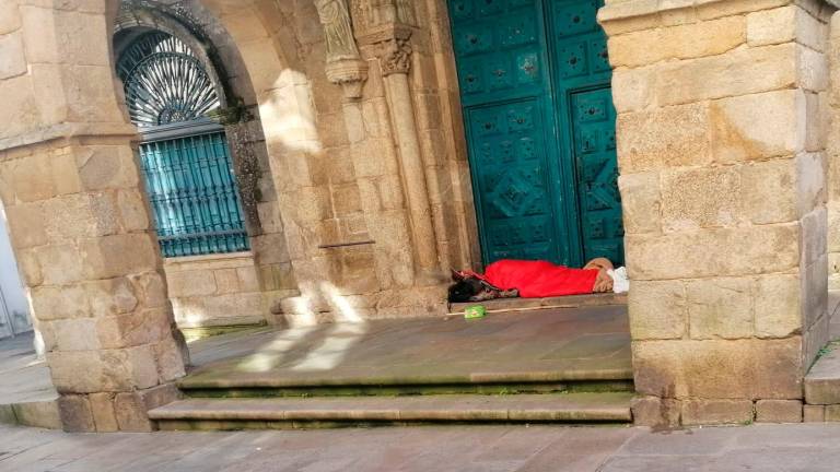 Una persona durmiendo en el pórtico de la iglesia parroquial de Santa María Salomé, en plena Rúa Nova
