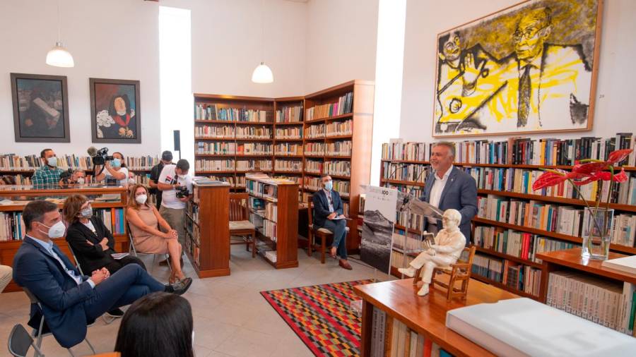 Pedro Sánchez escucha al presidente canario, debajo de un retrato de Saramago. Foto: E. Press