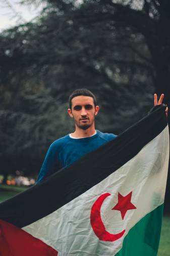 Salamu Chej sostiene la bandera que reclama la República Saharaui. Foto: Toni Pérez Vilas