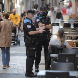 A CORUÑA, 13-08-20.- Dos agentes de la polcia local de A Coruña se dirigen a un hombre que se encontraba fumando en una terraza de un bar de la ciudad. EFE/ CABALAR