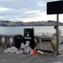 Un joven junto a restos de basura en una de las salidas de la playa de Orzán, después de la celebración de las hogueras de la noche de San Juan, en la playa de Orzán, a 24 de junio de 2022, en A Coruña, Galicia (España). M. Dylan / Europa Press 23/06/2022