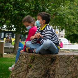 COVID. Dos niños con mascarilla sentados en la Alameda de Santiago. Foto: Angy Álvarez