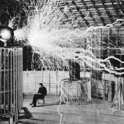 Nikola Tesla sentado en su laboratorio con su Magnifying Transmitter. (Fuente, www.culturainquieta.com)
