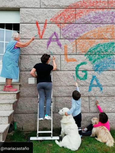 Una familia de Valga pintando el arcoíris en su casa Foto: C. 