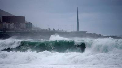 A CORUÑA, 04/12/2020.- En la imagen, oleaje que rompía con fuerza contra las rocas de la ciudad de A Coruña, con el obelisco Millenium al fondo. EFE/Cabalar
