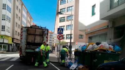 Personal de Serra do Barbanza retirando la basura en contenedores de la localidad de O Milladoiro, Ames. Foto: C.D.A.