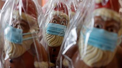 Figuras de chocolate de Papa Noel con mascarilla en las instalaciones de la compañía chocolatera Wawi en Pirmasens, Alemania, el 27 de noviembre de 2020. EFE/RONALD WITTEK