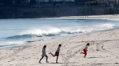 vacaciones. Tres niños juegan con la arena por la playa de Silgar (Sanxenxo). Foto: Lavandeira Jr (Efe)