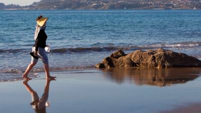 vigo. Mujer paseando por una playa en las Rías Baixas con la llegada de la primavera. Foto: Salvador Sas / Efe