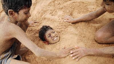 Niños indios jugando en la arena de la playa de Juhu en Mumbai. (Autor, Divyakant Solanki. Fuente, EFE)