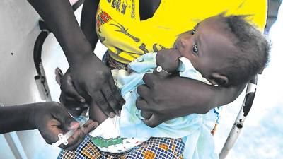 APOYO. Una mujer sostiene a un bebé mientras es vacunado gracias a la campaña que apoya Jealsa. Foto: Gavi 