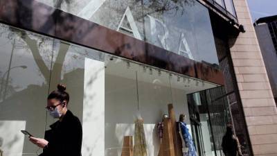 En la foto de archivo, una mujer con mascarilla pasa junto al escaparate de la tienda Zara de la Calle Princesa, en Madrid. EDUARDO PARRA/EUROPA PRESS