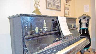 VILLAMIL Y REIGOSA. Piano centenario, con palmatorias, donado por los dueños de la farmacia local Villamil y Reigosa.
