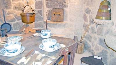 COCINA TRADICIONAL. Vajilla y cubertería en la recreación de una cocina tradicional con lareira y horno de leña.