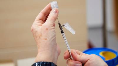 Una trabajadora sanitaria sostiene una jeringuilla con la segunda dosis de la vacuna de Pfizer-BioNTech antes de inocularla. Foto: E. Press