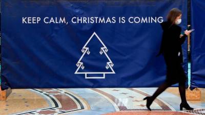 italia. Un cartel en una calle de Milán avisa de que hay que seguir con las medidas antiCOVID aunque se acerque la Navidad. Italia mantendrá el toque de queda desde las 22.00 horas incluso los festivos. Foto: Efe