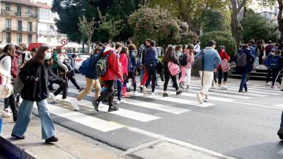 Un grupo de estudiantes cruza el paso de peatones a las puertas del IES Rosalía de Castro (Foto: Fernando Blanco)