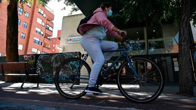 MADRID, 25/09/2020.- Una residente pasa en bici por delante del centro de salud García Noblejas, en el distrito madrileño de Ciudad Lineal, este viernes. EFE/Fernando Villar