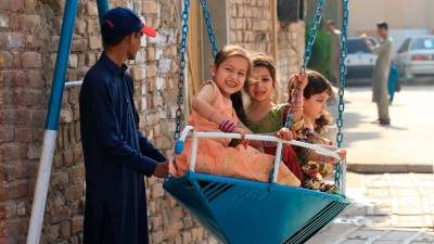 Niños montando un columpio en la celebración del fin del Ramadán en Pakistán. Efe