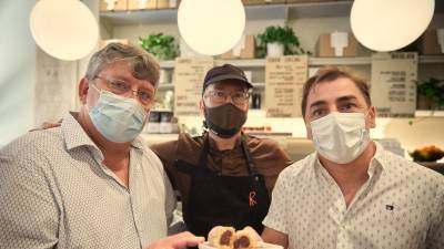 Jordi Roca, derecha, muestra el nuevo ‘chucho’, junto a un responsable de Can Castelló, izquierda, y el maestro chocolatero de Casa Cacao Damià Allsop Foto: EFE