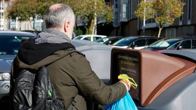 contenedor marrón. Un ciudadano de Santiago deposita materia orgánica con la que poder hacer compost . Foto: Gallego 
