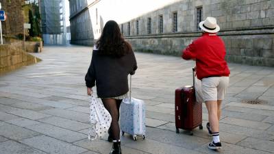 Turistas con sus maletas en el casco histórico de Santiago