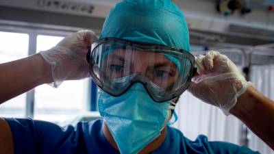 esfuerzo. Un trabajador sanitario se coloca las gafas de protección en la unidad de cuidados intensivos del Hospital Cosaga de Ourense. Foto: Brais Lorenzo 