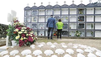 Una pareja ante las tumbas de un cementerio rural de Área de Compostela. Foto: Lavandeira JR