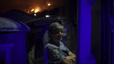 El restro de una mujer refleja la impotencia de los vecinos ante el avance de las llamas en el pueblo de Candeda, en Carballeda de Valdeorras. La imagen es del sábado FOTO: Brais Lorenzo