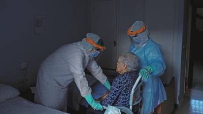 CELANOVA. Dos trabajadoras del centro San Carlos ayudando a acostarse a Clebella, de 84 años. Foto: Brais Lorenzo/Efe 