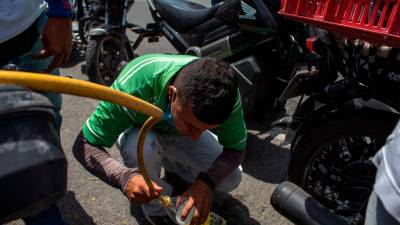 falta. Un hombre llena una botella con gasolina ante su escasez por los bloqueos (Cartago). Foto: S.Osorio 