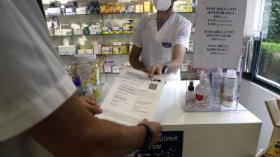 Un farmacéutico de Santiago muestra un certificado covid FOTO: A. Hernández