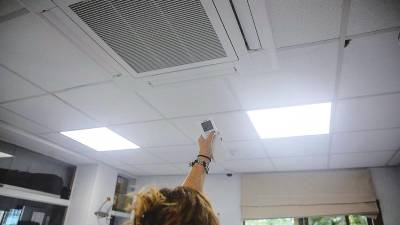 Una mujer regula la temperatura del aire acondicionado de la oficina. Foto: Ricardo Rubio/E.P.