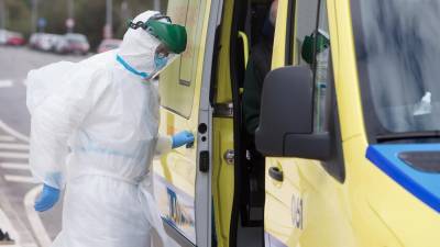 En la foto de archivo, un trabajador sanitario totalmente protegido cierra la puerta de una ambulancia en San Cibrao (Lugo). CARLOS CASTRO/EUROPA PRESS