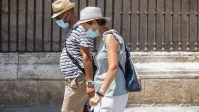 Dos personas caminan con mascarilla y sombrero durante una ola de calor FOTO: María José López- ARCHIVO