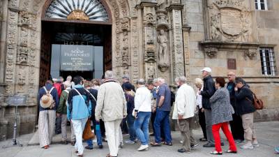 Un grupo de turistas accede al Parador Nacional de la capital gallega, situado en pleno Obradoiro. Foto: Antonio Hernández