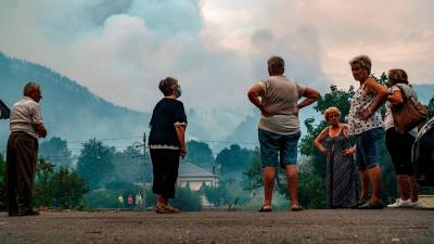 SAN CLODIO (LUGO), 06/09/2021.- Varios vecinos observan el incendio forestal declarado en la zona de San Clodio, este lunes en Lugo, con varios focos activos, que ha llegado incluso cerca de algunos pueblos. EFE/ Adra Pallón