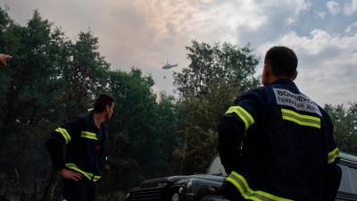 Dos bomberos observan un helicóptero trabajando en el incendio de la Sierra de la Culebra, a 17 de junio de 2022, en Zamora, Castilla y León (España). El fuego, que ha obligado a evacuar siete localidades, se ha complicado, según han señalado fuentes del operativo. // Emilio Fraile / Europa Press 17/06/2022