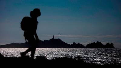 Silueta de un senderista recorriendo el Camiño dos Faros a su paso por la costa de Camariñá. Foto: Cabalar