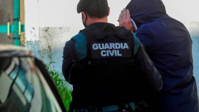 Un guardacivil acompaña a un detenido en una operación antidroga llevada a cabo recientemente en Galicia Foto: Sxenick