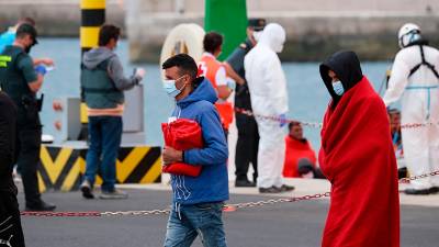 Dos migrantes con mantas de la Cruz Roja tras pisar territorio canario. Foto: E.P.