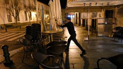 Foto de archivo de un camarero recogiendo la terraza de su establecimiento a la hora del cierre. FOTO: Álvaro Ballesteros