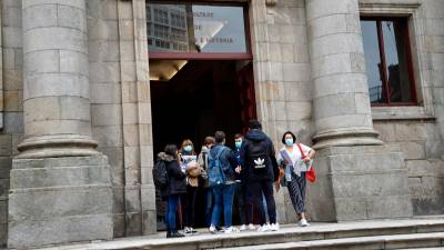 Un grupo de estudiantes universitarios en la entrada de la Facultade de Historia en Santiago. Foto: Fernando Blanco