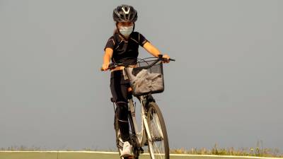 A MARIÑA. Una niña paseando ayer con su bicicleta y su mascarilla en el paseo marítimo de Foz. Foto: Eliseo Trigo 
