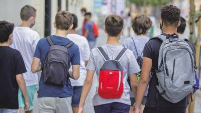 jóvenes con mochila a la salida de un colegio caminan en grupo hacia sus domicilios particulares. Foto: María José López / E:P.