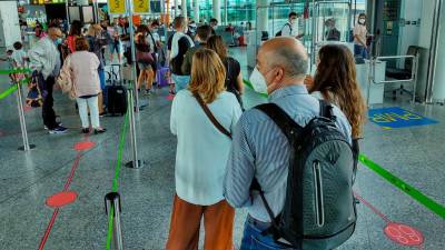 Pasajeros haciendo cola en el aeropuerto Rosalía de Castro para embarcar en sus vuelos. Foto: Fernando Blanco