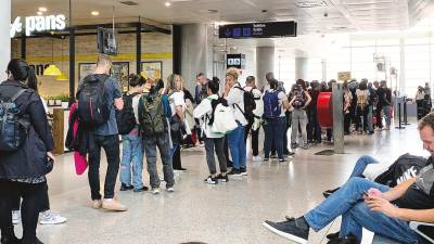 Larga cola de pasajeros a la espera de embarcar en Málaga ayer rumbo a la capital gallega