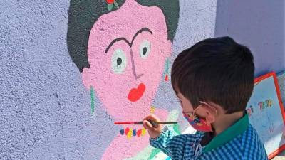 Un cativo da Escola de Educación Infantil Rosalía de Castro de Rianxo colaborando na elaboración do mural. Foto: EEI R. de Castro